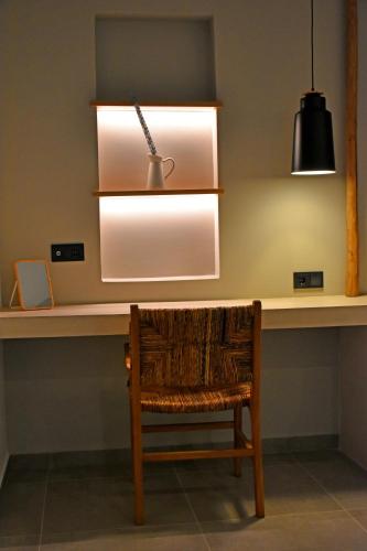 a chair sitting at a desk with a light at Opuntia Boutique Hotel in Kalívia