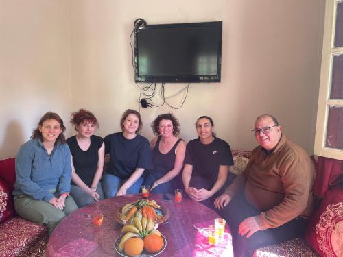 a group of people sitting around a table at Spacious Apartment with Motorcycle Garage, Free Parking, and Air Conditioning in Er Rachidia