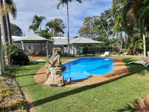 a pool with a statue next to a yard at Cleveland Motor Inn in Cleveland