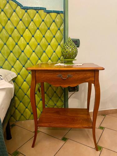 a small wooden table with a vase on it at Bed & Breakfast Casa Anna Rita in Vietri sul Mare