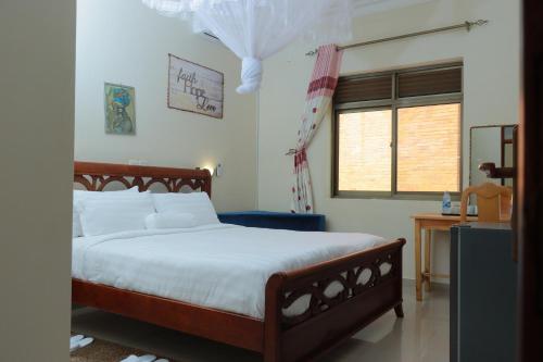 a bedroom with a large bed and a window at Mowicribs Hotel and Spa in Entebbe