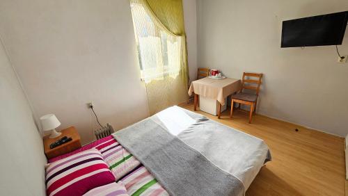 sypialnia z łóżkiem i stołem z telewizorem w obiekcie Willa Daniela w Rewalu
