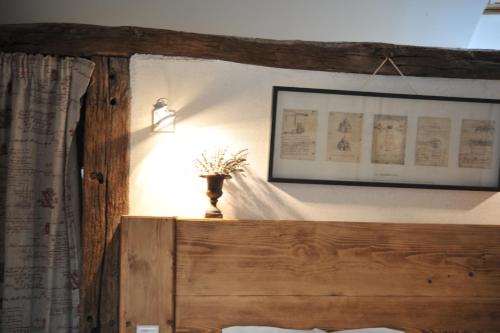 a bedroom with a bed with a lamp and a picture on the wall at La Bergerie Du Château De Pommeuse in Pommeuse