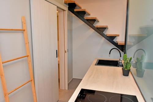 a kitchen with a sink and a staircase at Opuntia Boutique Hotel in Kalívia