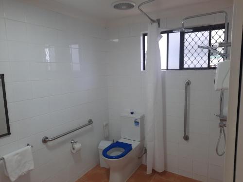 a bathroom with a toilet with a blue seat at Cleveland Motor Inn in Cleveland