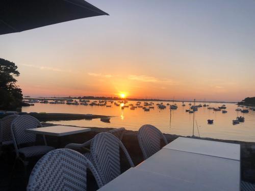un coucher de soleil sur un port avec des bateaux dans l'eau dans l'établissement Appartement idéalement situé, à Arzon