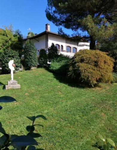 a house with a yard with a statue in the grass at Penthouse in the green with private pool and garden in Portula