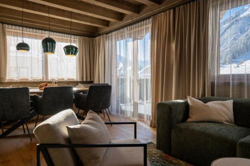 a living room with a couch and a table with chairs at Luf Lodges in Ischgl