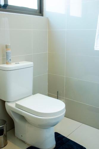 a white toilet in a bathroom with a window at Guest House Auasblick by State House in Windhoek