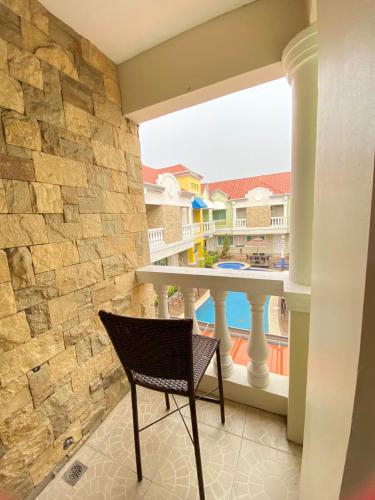 a chair on a balcony with a view of a building at Prism Hotel in Angeles