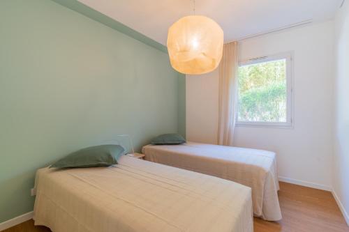 deux lits dans une chambre avec une fenêtre dans l'établissement Le Saint Jean, à 10 minutes de la plage, à La Ciotat