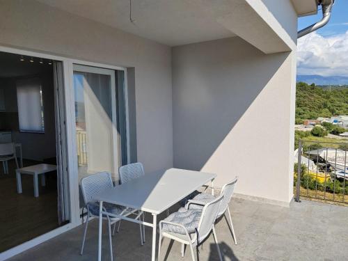 a white table and chairs on a balcony at Martina in Rab