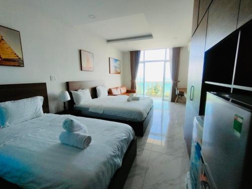 a hotel room with two beds with towels on them at Comfortable Family Apartment at Sealinks Mui Ne in Ấp Ngọc Hải