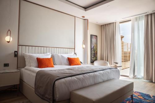 a bedroom with a large bed with orange pillows at KARAVANSARAY Turkistan Family Hotel - FLYING THEATRE ACCESS in Türkistan