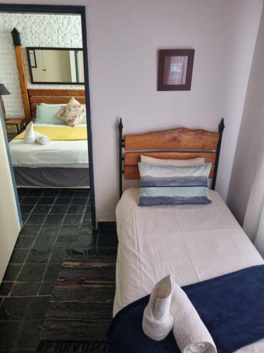 a bedroom with two beds and a mirror at Gorgeous Gecko Guesthouse in Modimolle