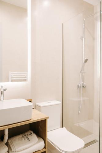 a white bathroom with a sink and a shower at Volos Suites Center in Volos