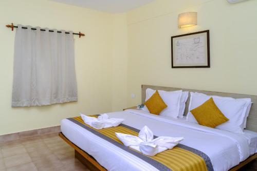 a bedroom with a bed with white flowers on it at Lifestyle villa in Candolim