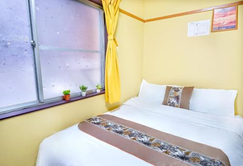 a bedroom with two beds and a window at 鹿の宿 in Osaka