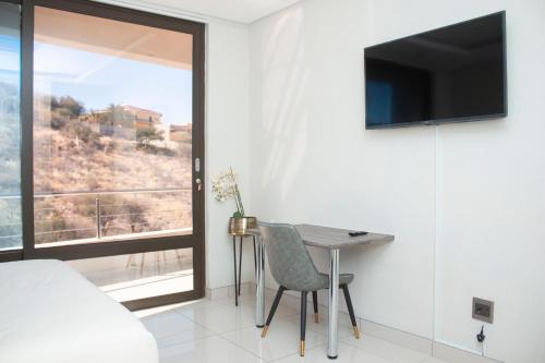 a bedroom with a bed and a table and a window at Guest House Auasblick by State House in Windhoek
