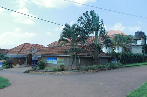a house with palm trees in front of it at Mowicribs Hotel and Spa in Entebbe