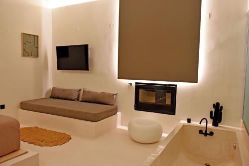 a living room with a couch and a fireplace at Opuntia Boutique Hotel in Kalívia