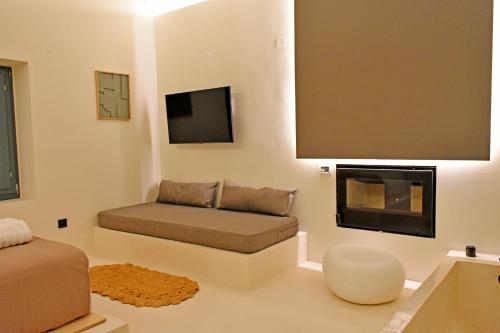 a living room with a couch and a fireplace at Opuntia Boutique Hotel in Kalívia