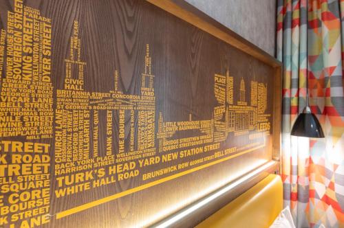 a picture of a wall with a poster on it at ibis Styles Leeds City Centre Arena in Leeds