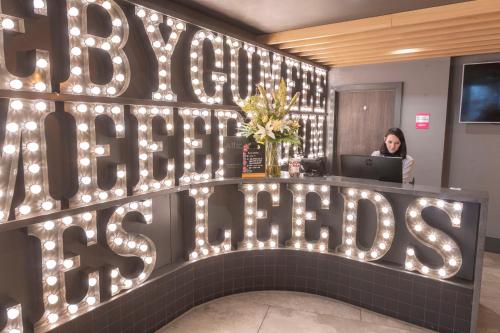 a woman sitting at a desk with a laptop at ibis Styles Leeds City Centre Arena in Leeds