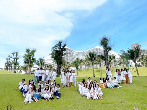 a group of people in white posing for a picture at The KH Cam Ranh Nha Trang Beachside in Thôn Hòa Ða