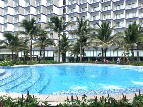 a large swimming pool in front of a hotel at The KH Cam Ranh Nha Trang Beachside in Thôn Hòa Ða