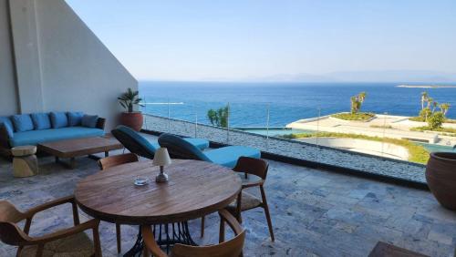 a patio with a table and chairs and the ocean at Swissôtel Living Bodrum in Bodrum City