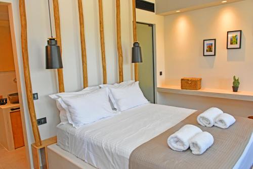 a bedroom with a bed with towels on it at Opuntia Boutique Hotel in Kalívia