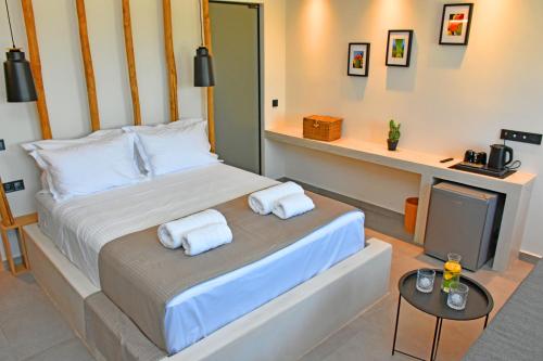 a bedroom with a bed with towels on it at Opuntia Boutique Hotel in Kalívia