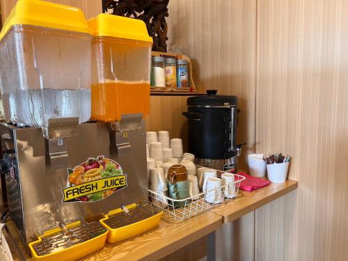 a drink dispenser on top of a counter with food at Berich Hotel in Tak