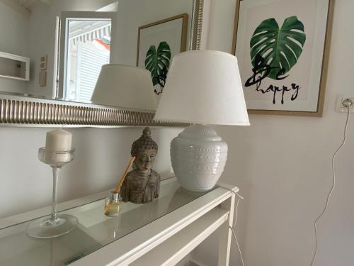 a table with a lamp and a statue on it at Calma bungalows in Portorož