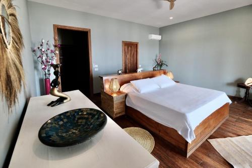 a bedroom with a bed and a table with a bowl on it at Maharaja Boutique Hotel Zanzibar in Uroa