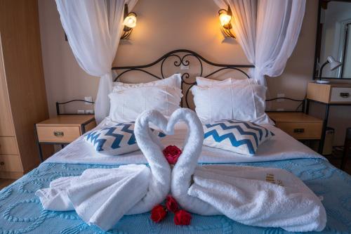two swans making a heart on a bed at Coralli Rooms & Restaurant in Elafonisos