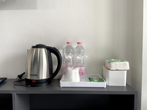a coffee maker and two bottles of water on a table at OK Hotel Bangkok in Bangkok