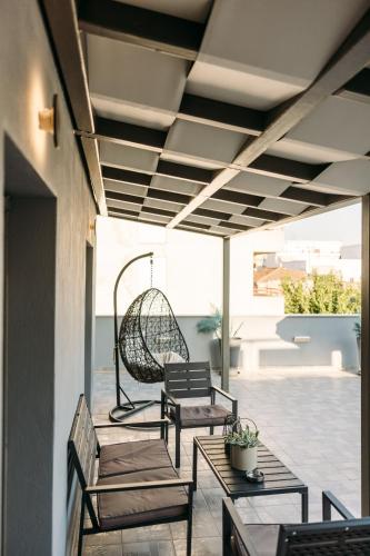 a patio with two chairs and a swing at Volos Suites Center in Volos