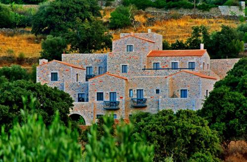 a large stone building in the middle of trees at Opuntia Boutique Hotel in Kalívia