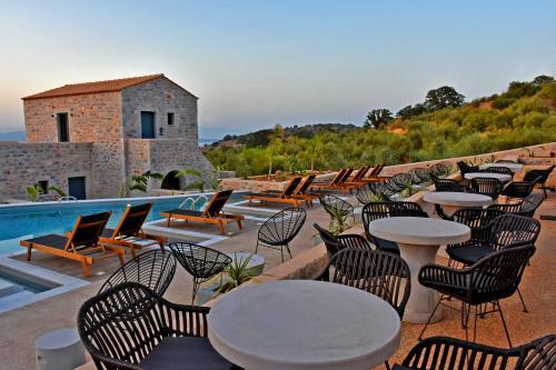 a group of tables and chairs next to a pool at Opuntia Boutique Hotel in Kalívia