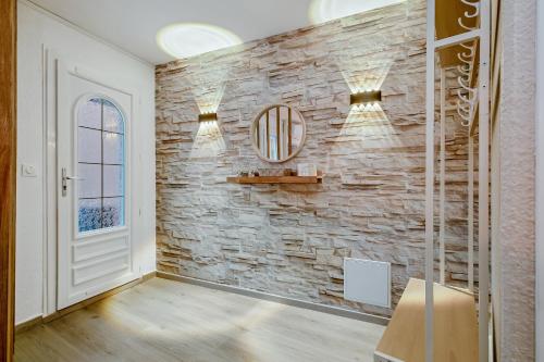 Cette chambre est dotée d'un mur en pierre et d'un miroir. dans l'établissement Mer et Toison d'or - Duplex entièrement climatisé, au Cap d'Agde