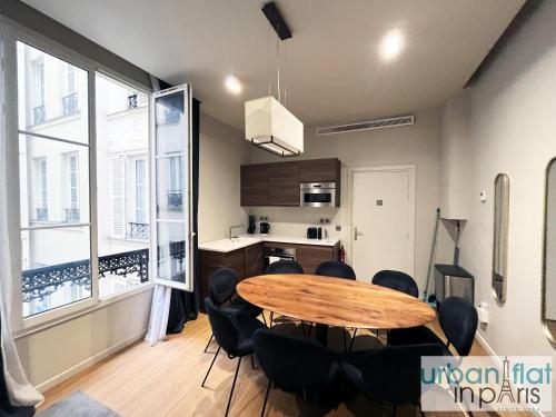une cuisine et une salle à manger avec une table et des chaises dans l'établissement Urban Flat 110 - Luxury 3 Bedroom near Galeries Lafayette, à Paris