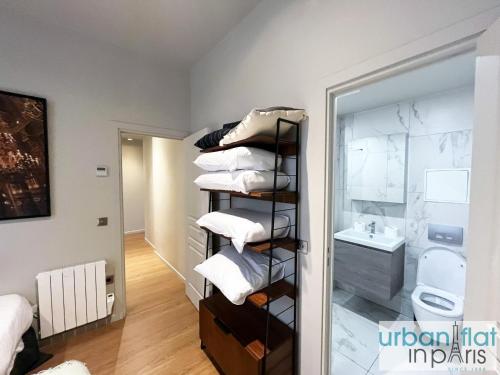 une chambre avec une pile de serviettes et une salle de bain dans l'établissement Urban Flat 110 - Luxury 3 Bedroom near Galeries Lafayette, à Paris
