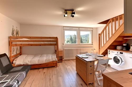 - une chambre avec des lits superposés et un bureau avec une table dans l'établissement Le Nid des Vosges - Appt vue montagne, à Gérardmer