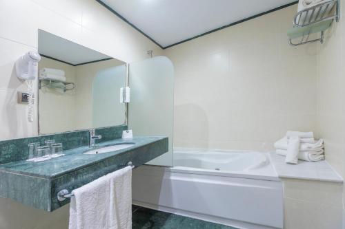 a bathroom with a sink and a tub and a mirror at Moon Dreams Calabahía in Cala del Moral
