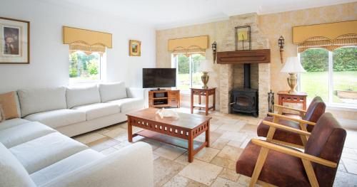 a living room with a couch and a table at Stunning 4-Bedroom Country House with Hot Tub & Sauna near Loch Lomond in Glasgow