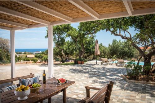 a table with a bowl of fruit on a patio at Villa Roza by Prime Stay in Stalida