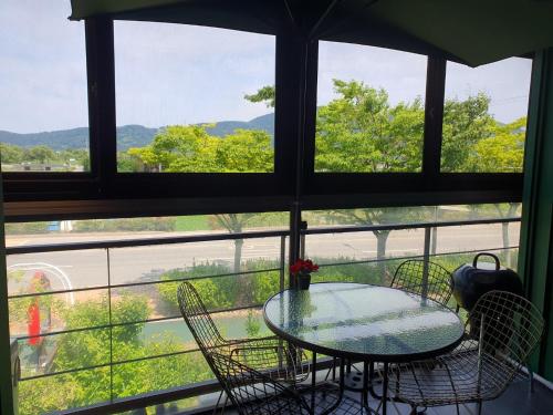 a table and chairs on a balcony with a view at Four Seasons Pension in Suncheon