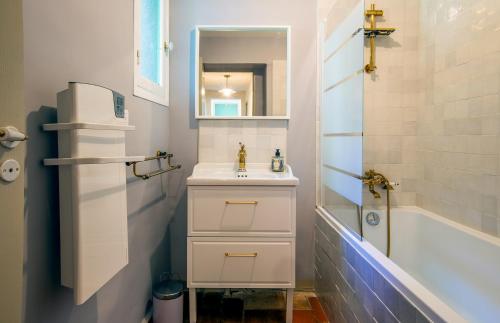 une salle de bain blanche avec lavabo et douche dans l'établissement Gîte nature avec piscine privée, à Montagnac